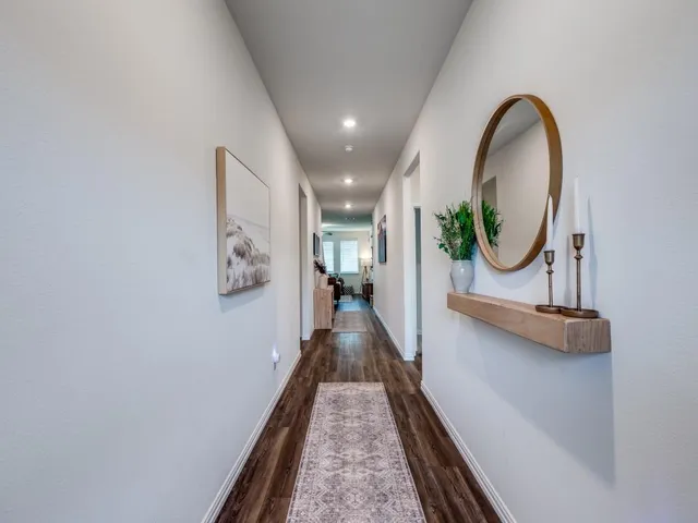 a view of a hallway with wooden floor and a sink