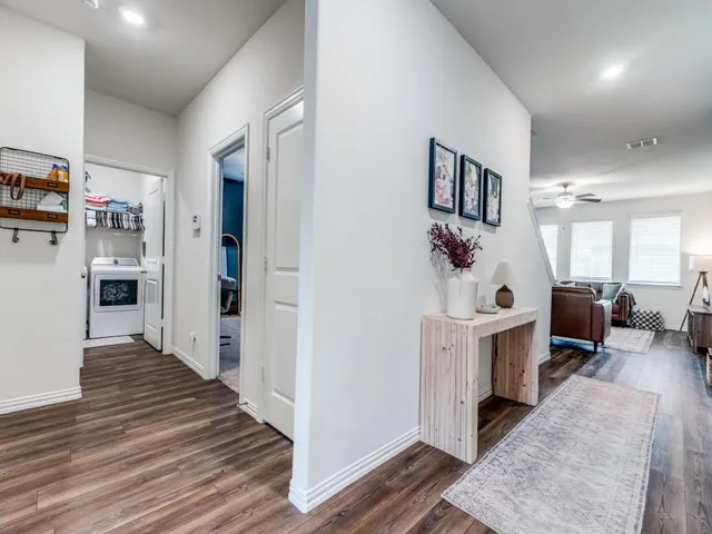 a view of a hallway with furniture and wooden floor