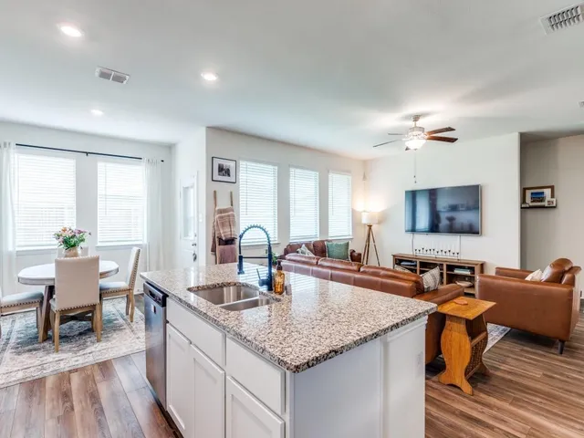 a kitchen with sink and living room