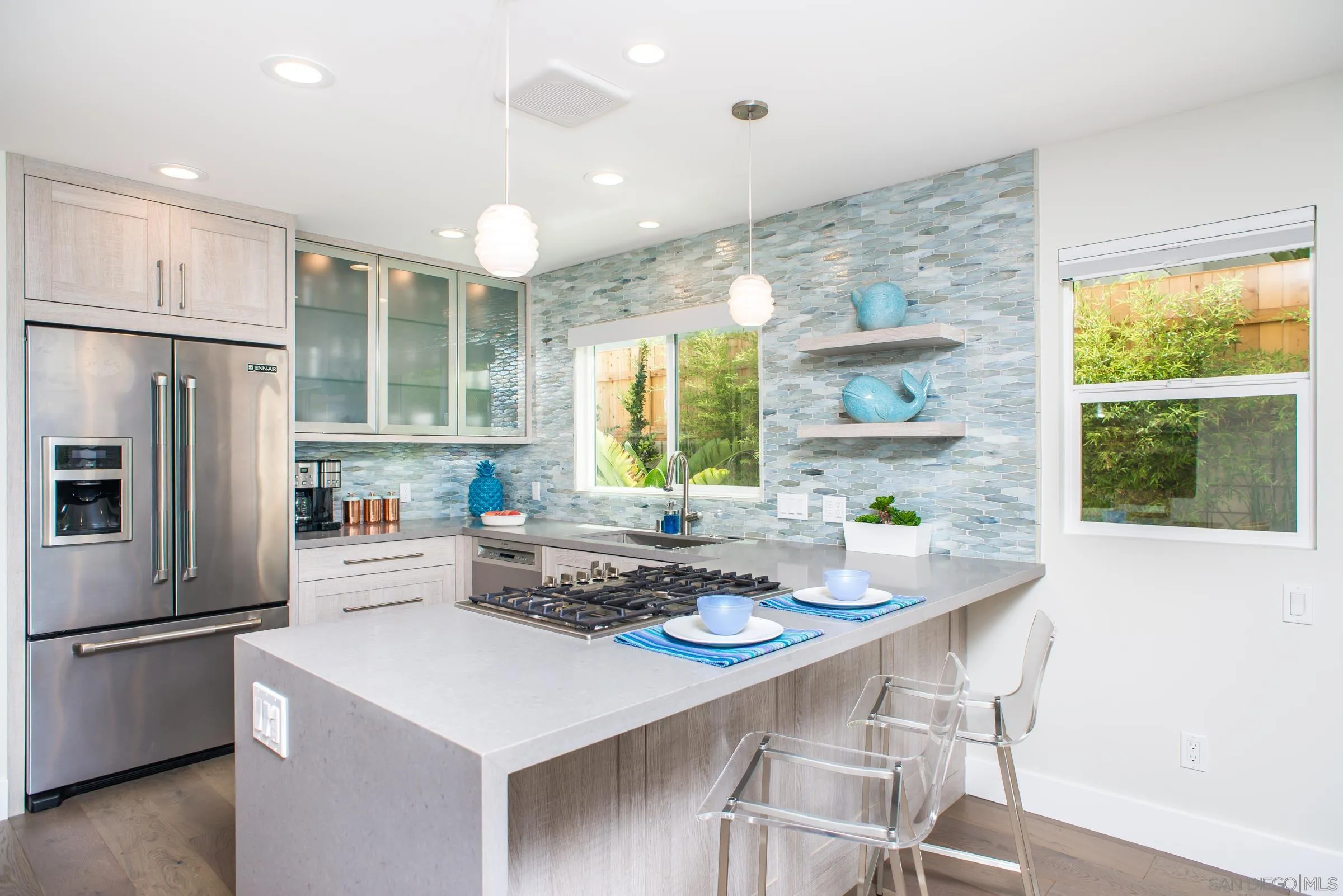 129 West Jason Street Encinitas, CA 92024 - Photo 10 of 44 a kitchen with stainless steel appliances a refrigerator a stove a dining table and chairs with wooden floor