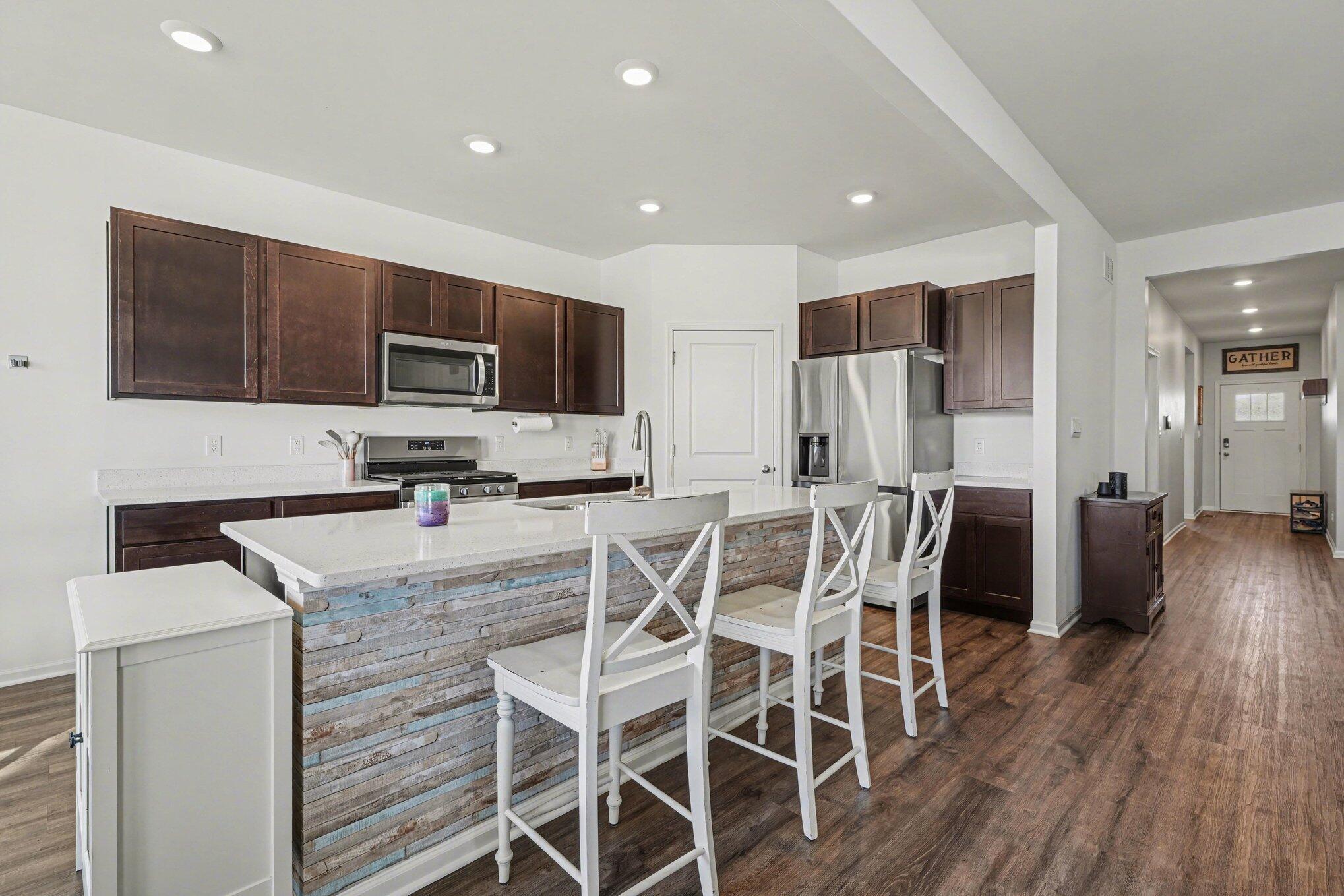 7787 West 105th Place Crown Point, IN 46307 - Photo 12 of 32 a kitchen with stainless steel appliances kitchen island granite countertop a refrigerator and microwave