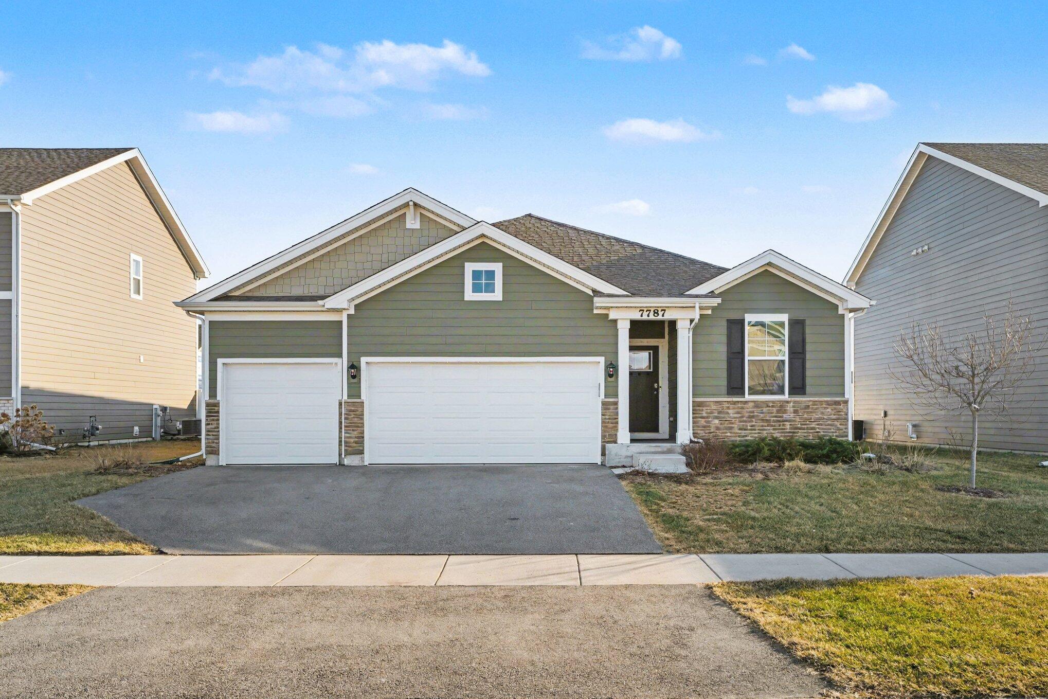 7787 West 105th Place Crown Point, IN 46307 - Photo 3 of 32 a front view of a house with a yard and garage