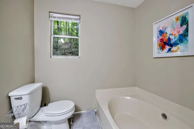 a white toilet sitting next to a bath tub