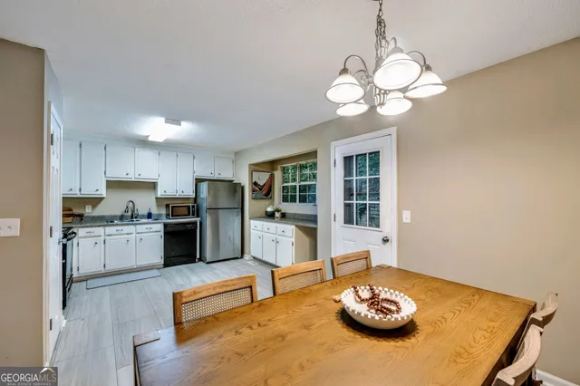 a kitchen with stainless steel appliances granite countertop a sink dishwasher stove refrigerator and couches with wooden floor