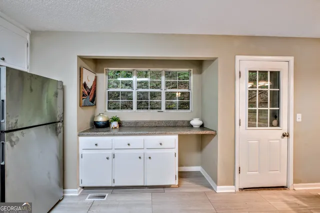 a kitchen with granite countertop a refrigerator and a sink