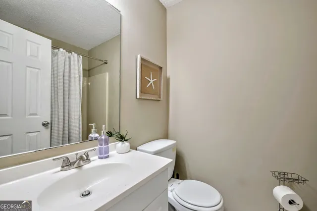 a bathroom with a sink mirror vanity and toilet