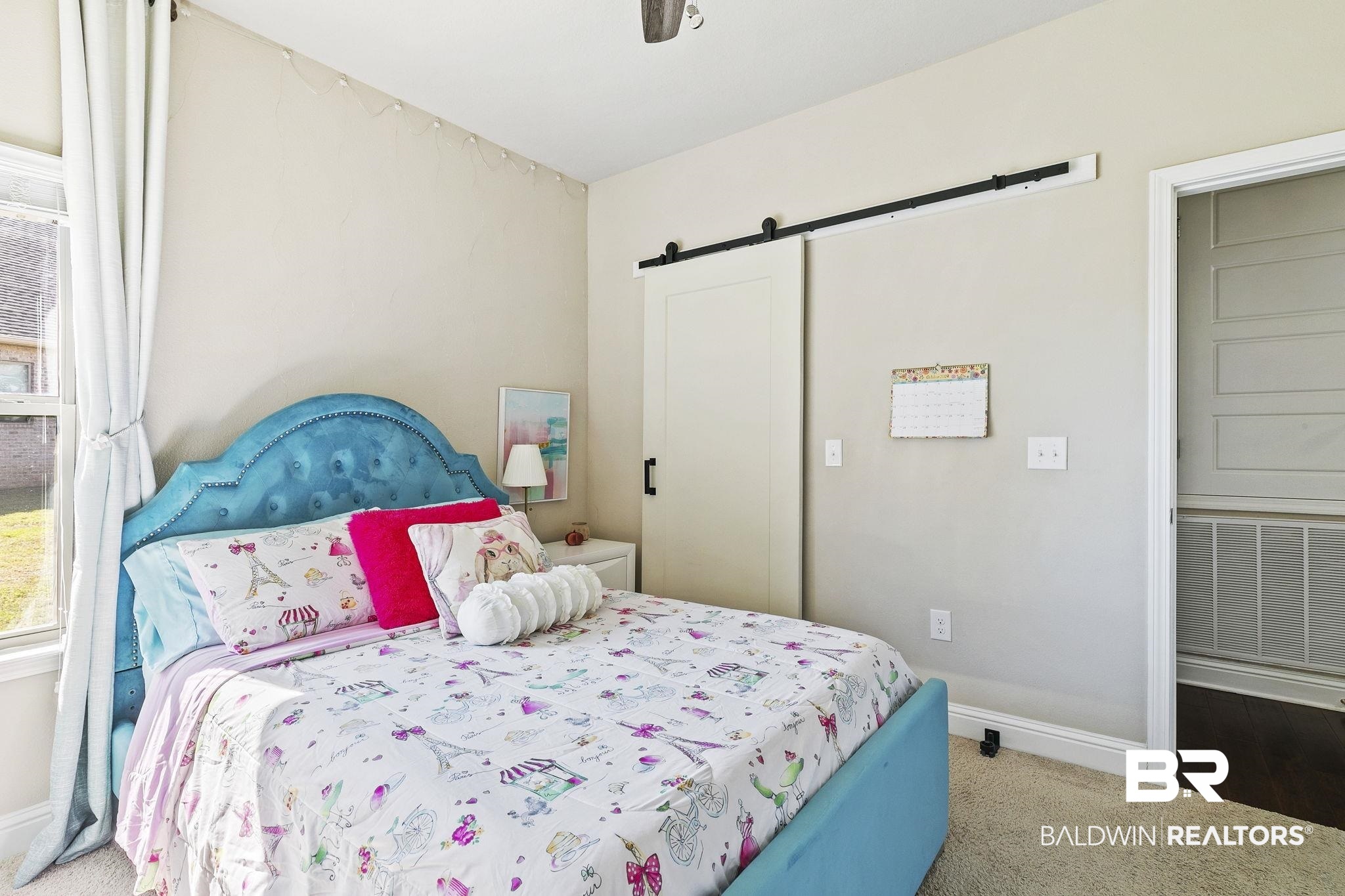 31500 Spoonbill Road Daphne, AL 36527 - Photo 37 of 85 Carpeted bedroom with a barn door and ceiling fan