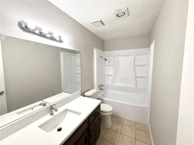 a bathroom with a bathtub shower sink vanity and a toilet
