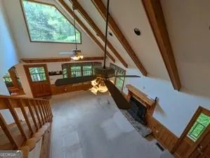 an empty room with windows cabinet and ceiling fan
