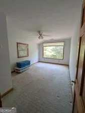 an empty room with wooden floor fireplace and windows
