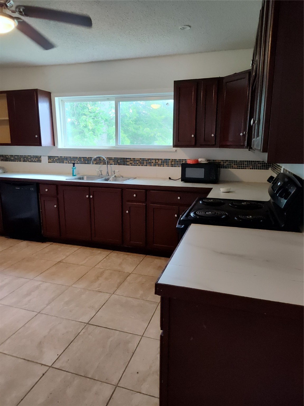 527 West 6th Street Freeport, TX 77541 - Photo 5 of 25 a kitchen with a sink a stove and wooden cabinets
