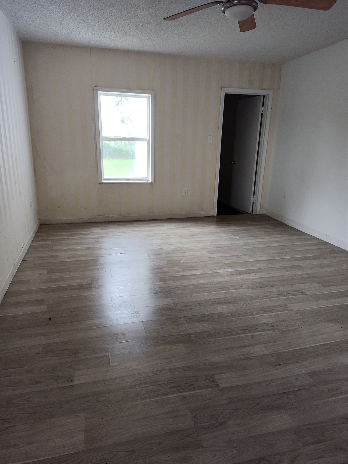527 West 6th Street Freeport, TX 77541 - Photo 8 of 25 an empty room with wooden floor and windows