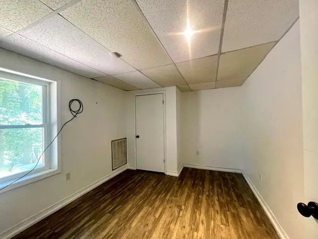 a view of a room with wooden floor and window