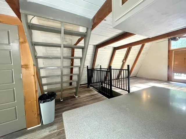a view of a hallway with wooden floor and stairs