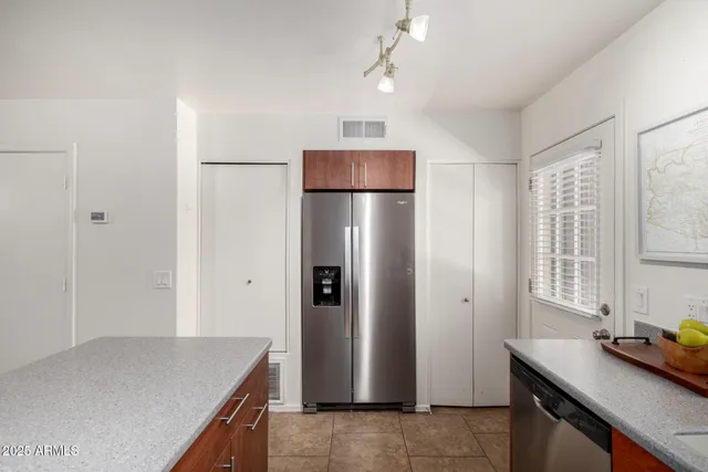 a kitchen with stainless steel appliances granite countertop a refrigerator and a sink