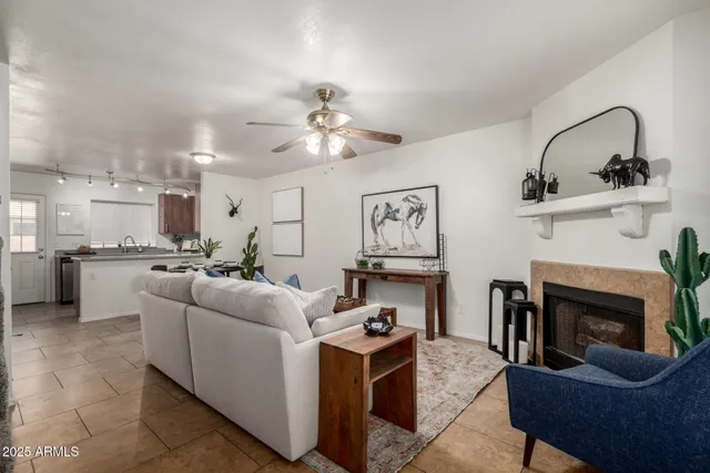 a living room with furniture a fireplace and kitchen view