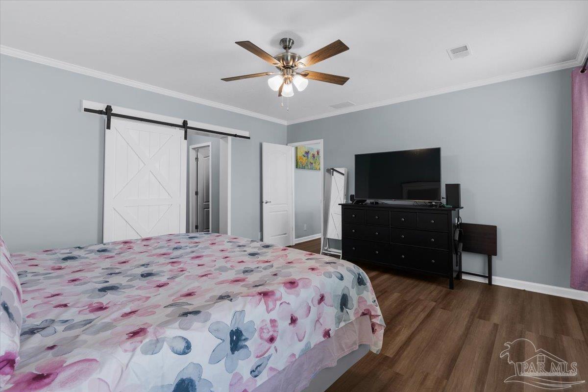 4955 Blue Ribbon Drive Milton, FL 32583 - Photo 10 of 32 a bedroom with a bed and a flat screen tv