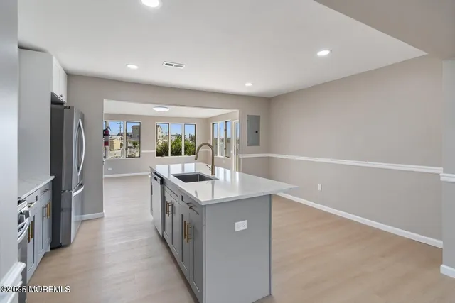 a kitchen with stainless steel appliances a sink and a refrigerator