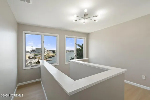 a living room with stainless steel appliances furniture a large window and a kitchen view