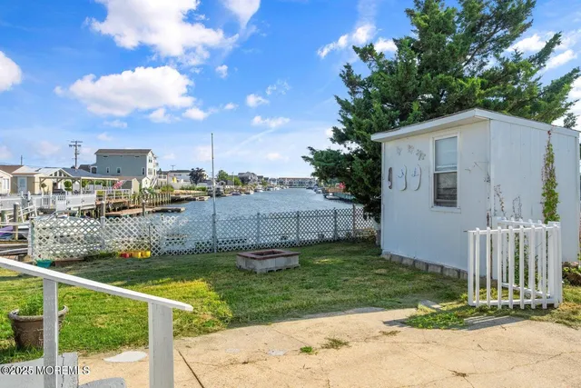 a view of a house with backyard and tree