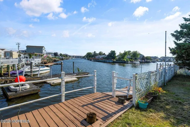 a balcony with wooden benches and lake view