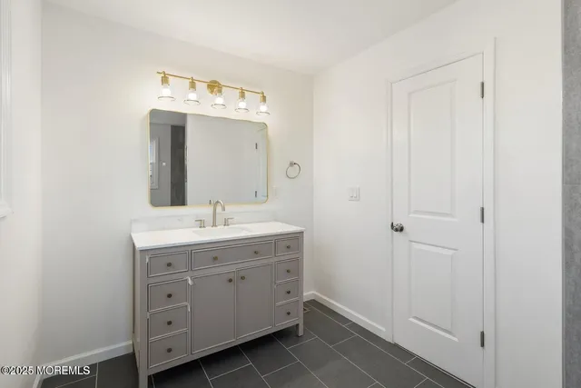 a bathroom with a granite countertop sink and a mirror