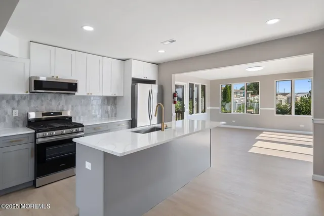 a kitchen with stainless steel appliances granite countertop a stove a sink and a refrigerator