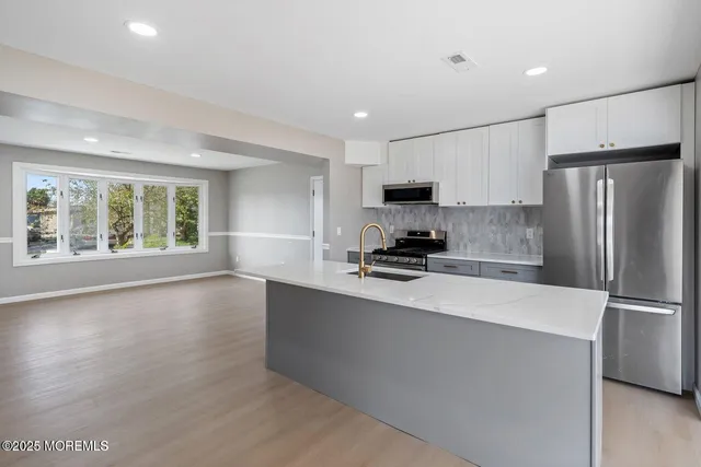 a kitchen with stainless steel appliances a refrigerator sink and microwave