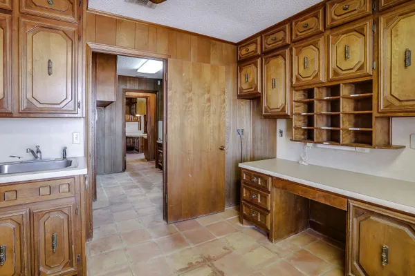 an empty room with wooden floor chandelier fan and windows