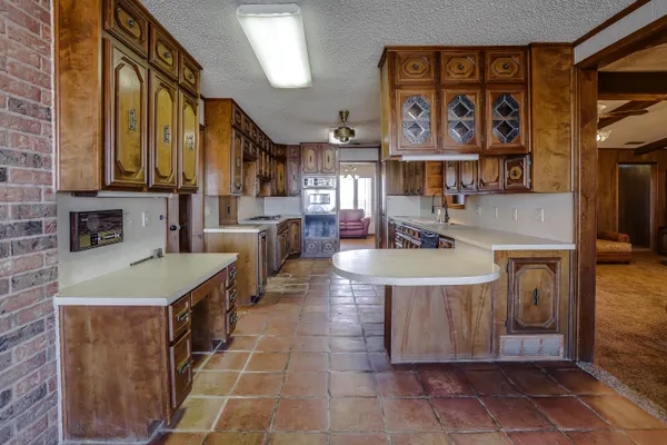 a kitchen with a stove a cabinets and chairs