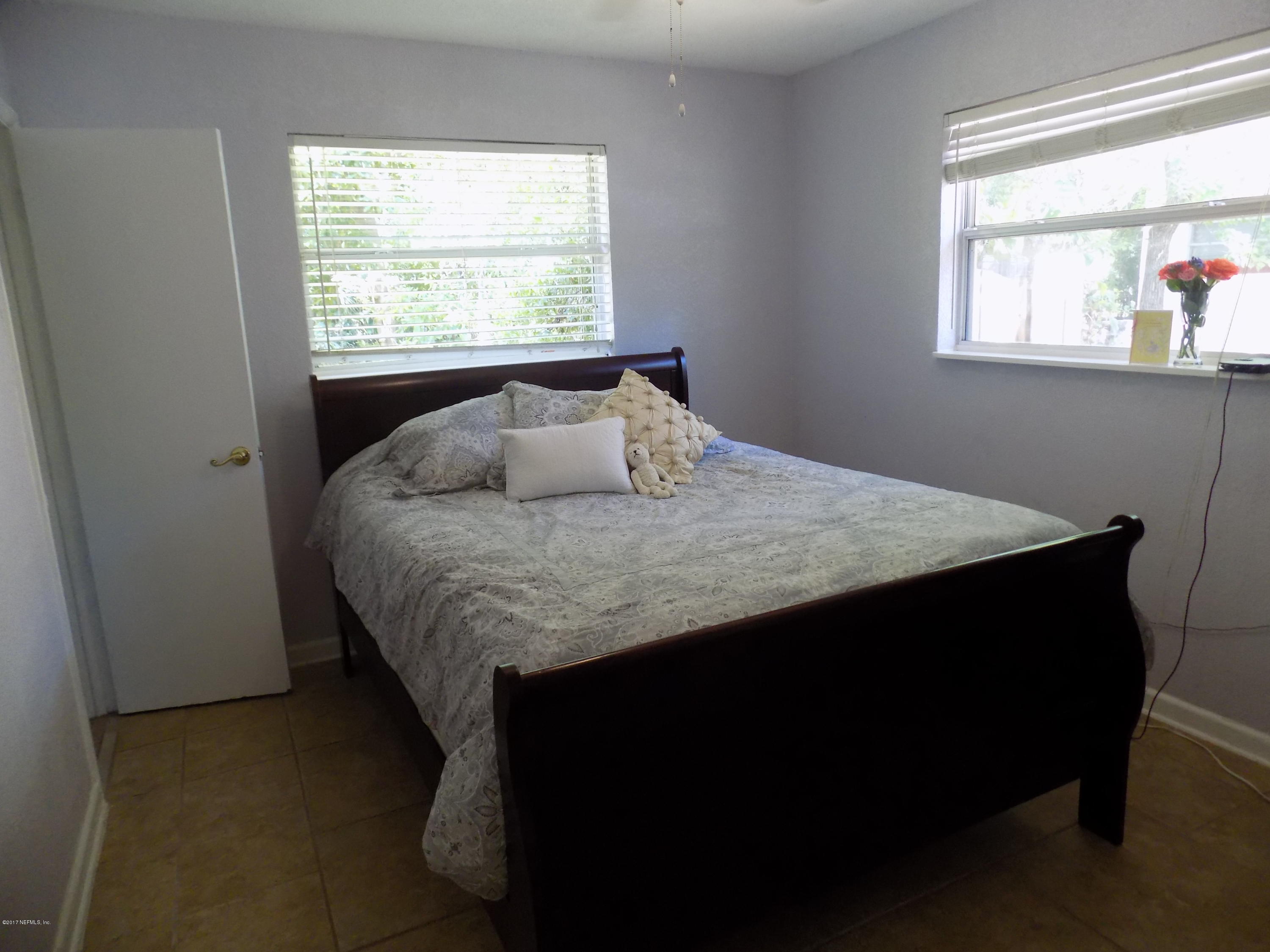 3738 Rogero Road Jacksonville, FL 32277 - Photo 12 of 22 a bed sitting in a bedroom next to a window