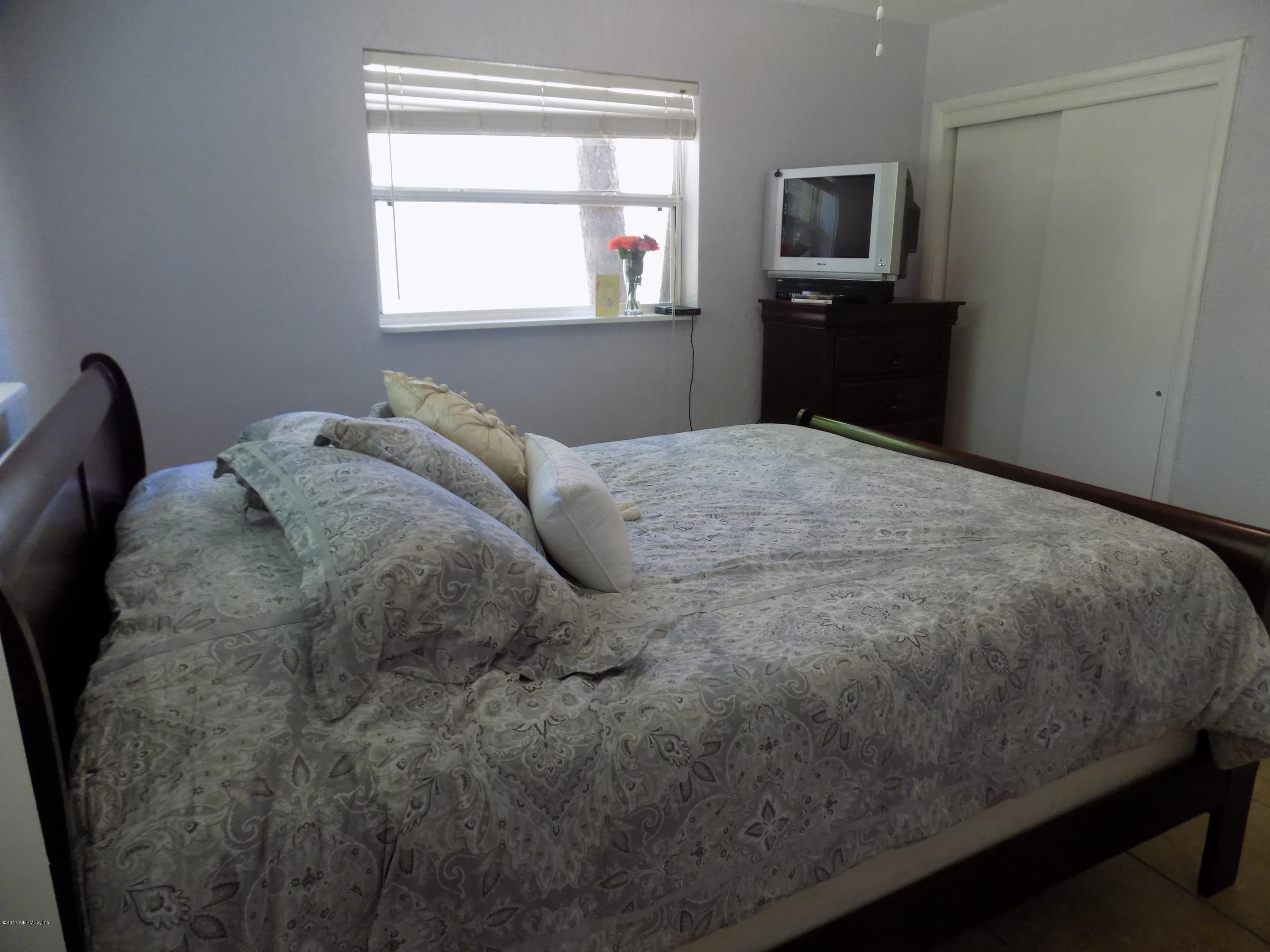 3738 Rogero Road Jacksonville, FL 32277 - Photo 13 of 22 a bedroom with a bed and a television