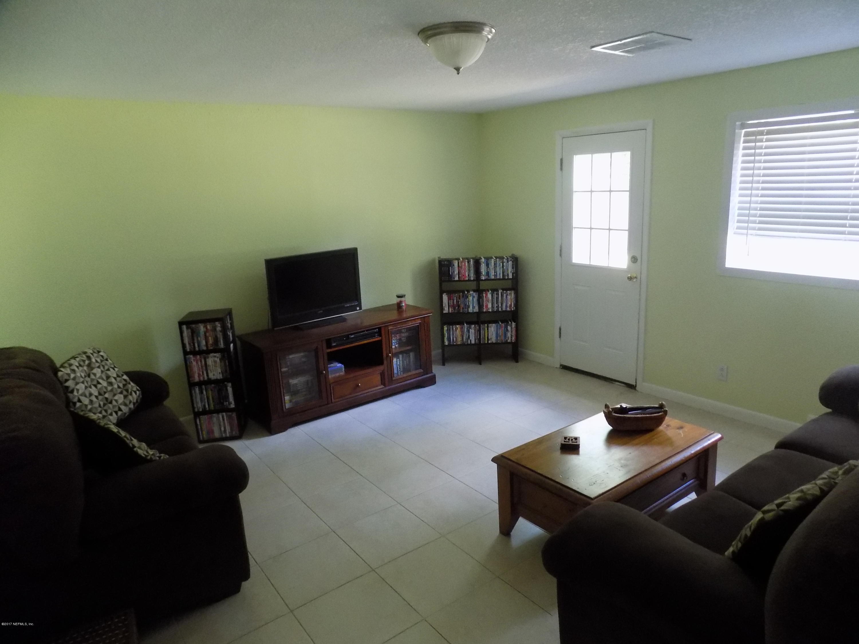 3738 Rogero Road Jacksonville, FL 32277 - Photo 18 of 22 a living room with furniture and a flat screen tv