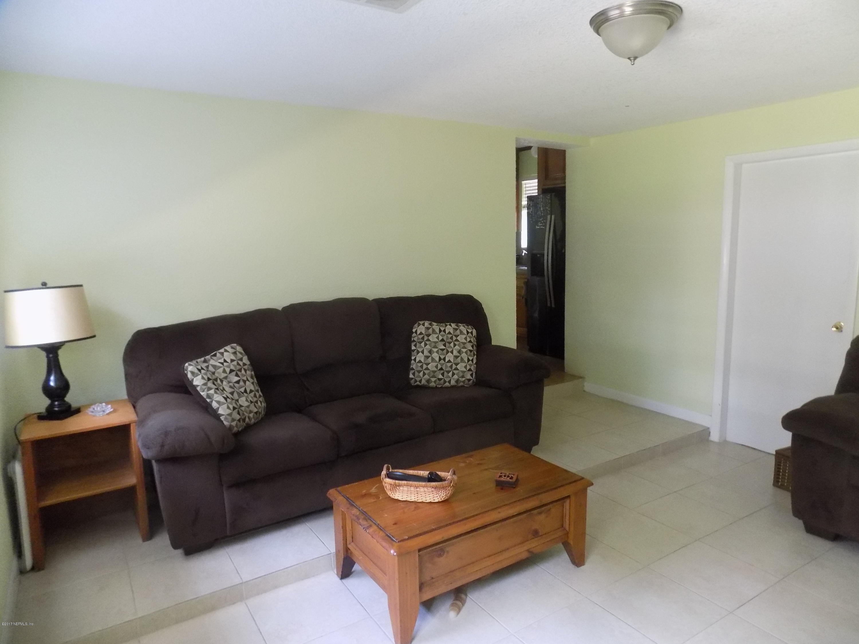 3738 Rogero Road Jacksonville, FL 32277 - Photo 19 of 22 a living room with furniture and a blue wall