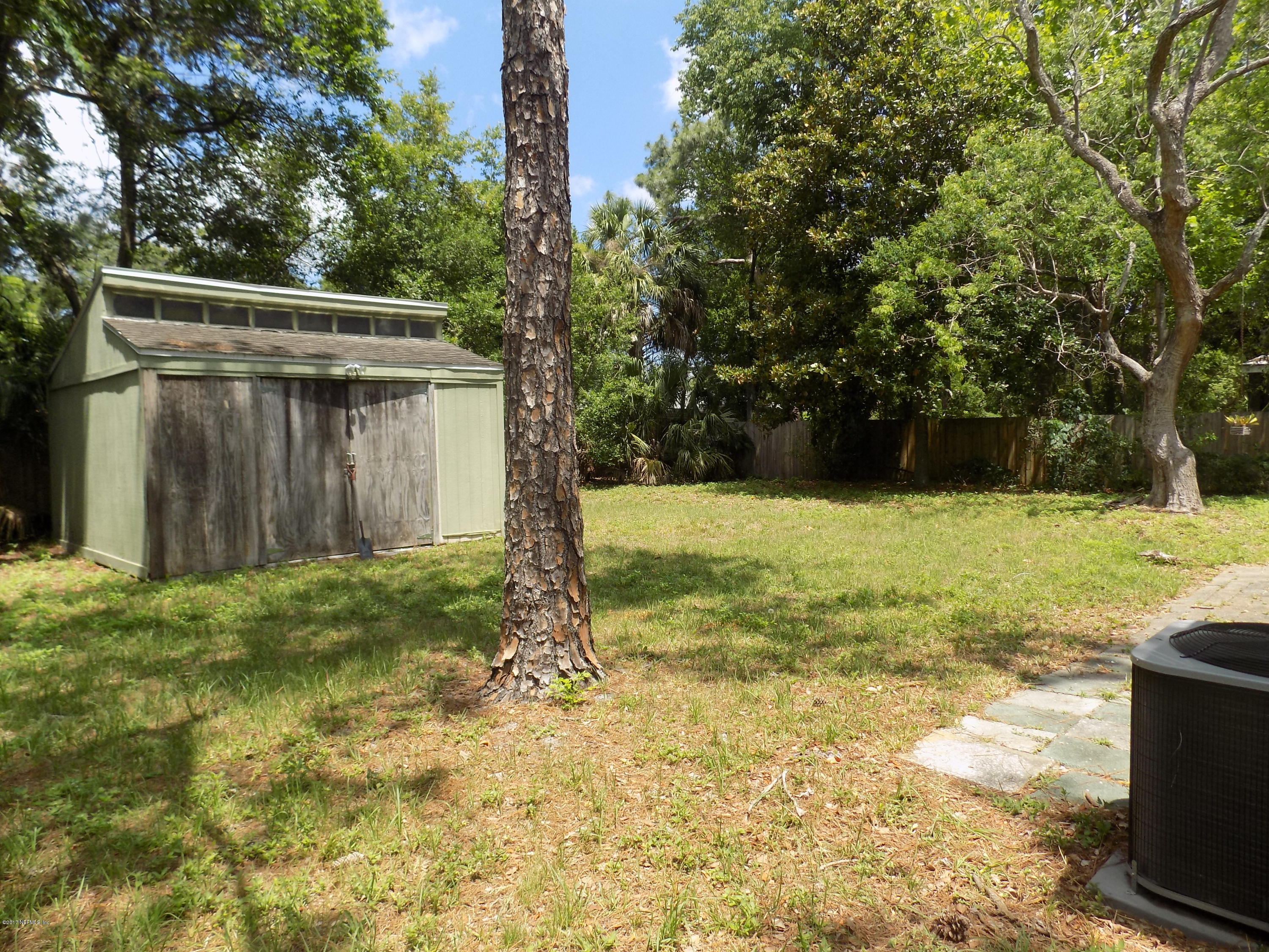 3738 Rogero Road Jacksonville, FL 32277 - Photo 22 of 22 a view of a backyard with large trees