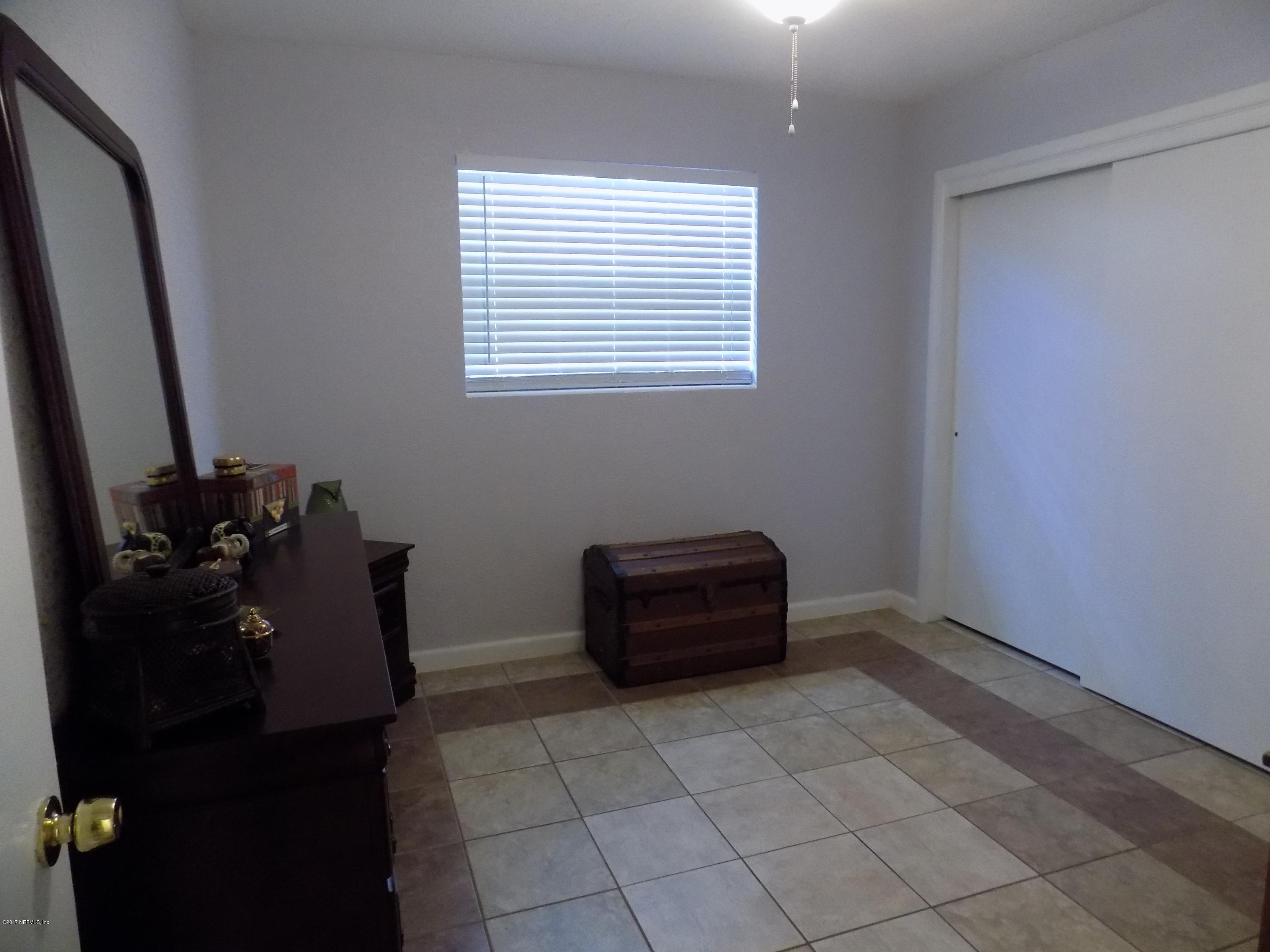 3738 Rogero Road Jacksonville, FL 32277 - Photo 8 of 22 a room with a black white checkered floor with a dishwasher next to a window