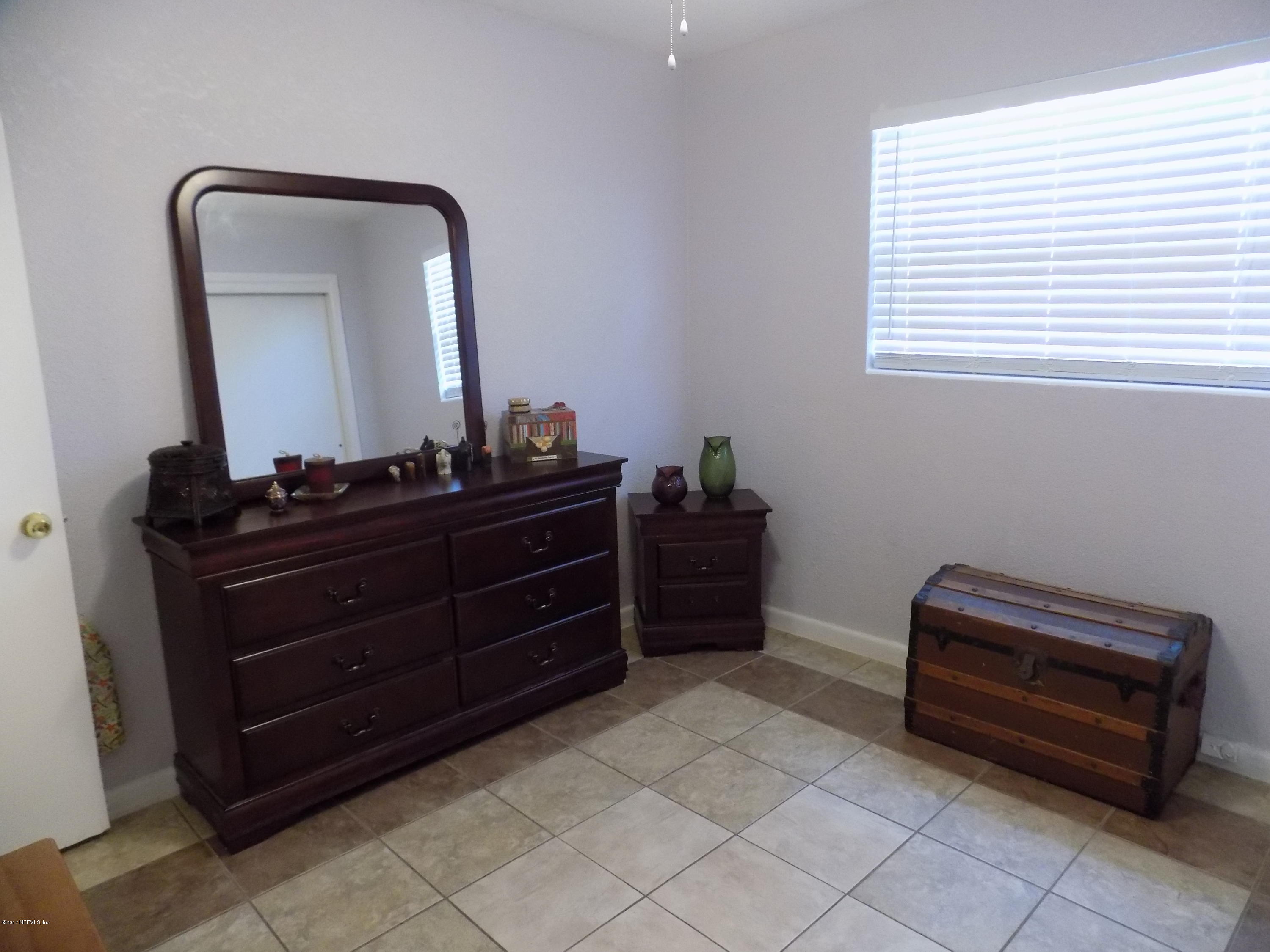 3738 Rogero Road Jacksonville, FL 32277 - Photo 9 of 22 a room with a dresser and a mirror