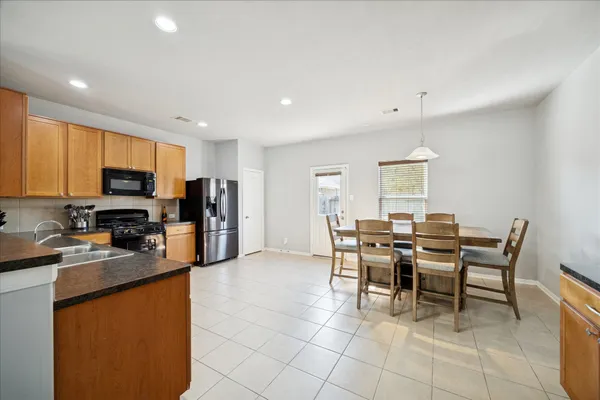 a kitchen with stainless steel appliances granite countertop a refrigerator and a stove top oven