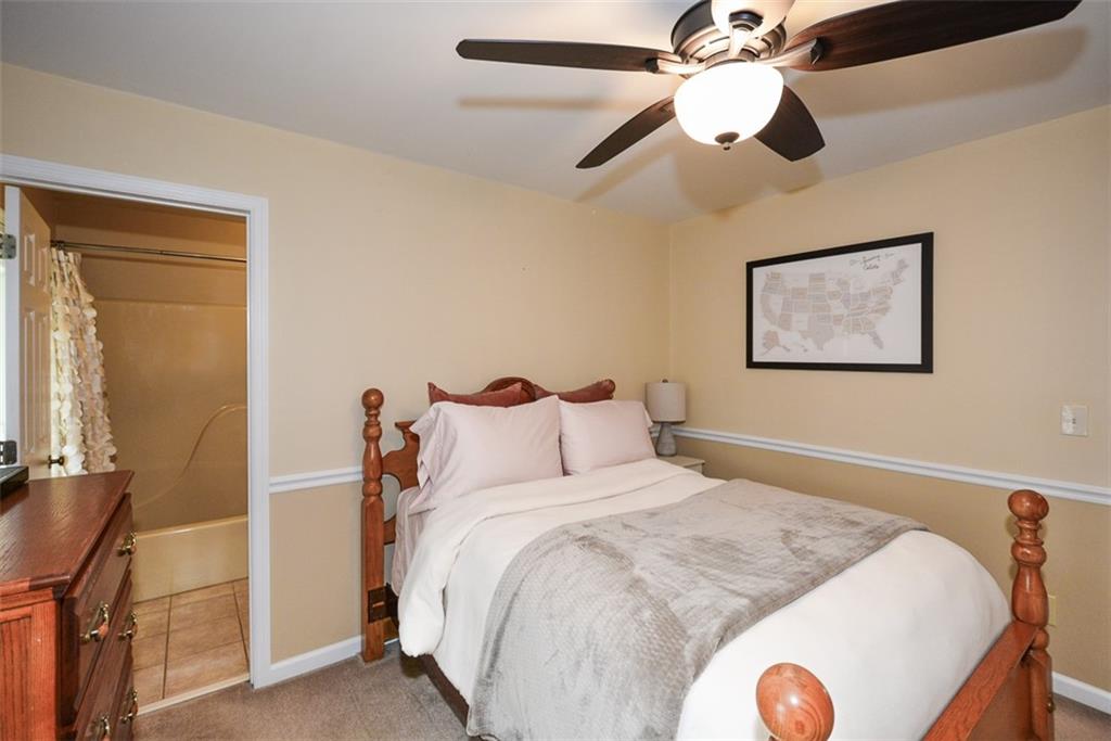 883 Tilley Road Talking Rock, GA 30175 - Photo 35 of 88 a bedroom with a large bed and a chandelier