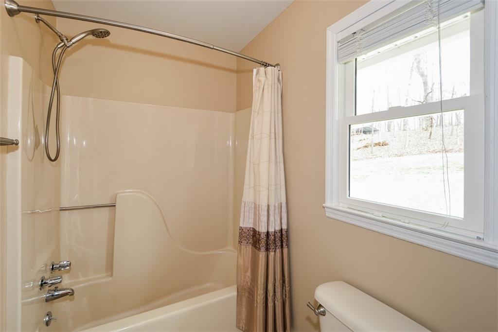 883 Tilley Road Talking Rock, GA 30175 - Photo 39 of 88 a bathroom with a shower a toilet and a window