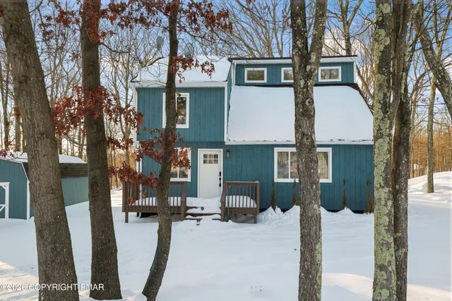 a backyard of a house with fire pit and outdoor seating