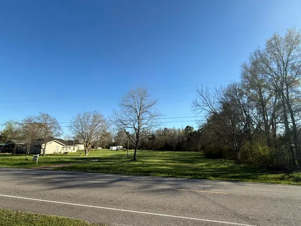 a view of a field with trees in the background