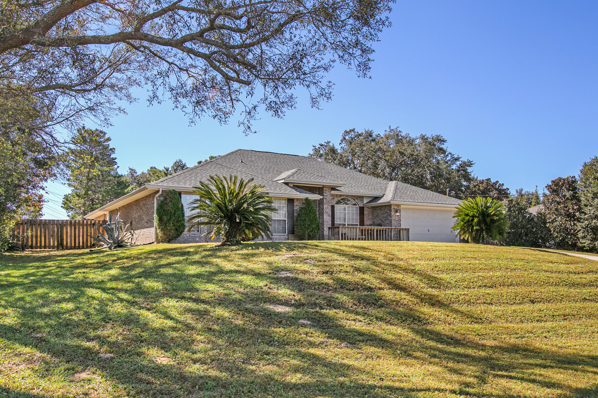 6735 Britt Street Navarre, FL 32566 - Photo 1 of 42 a yellow house with trees in front of it