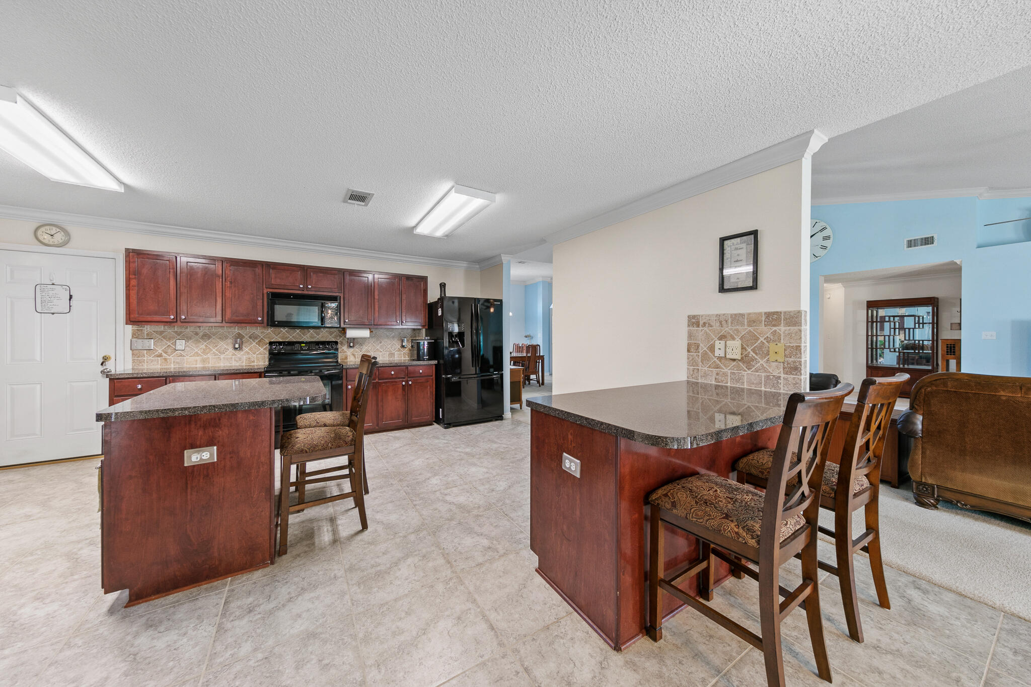 6735 Britt Street Navarre, FL 32566 - Photo 14 of 42 a living room with stainless steel appliances kitchen island granite countertop furniture and a refrigerator