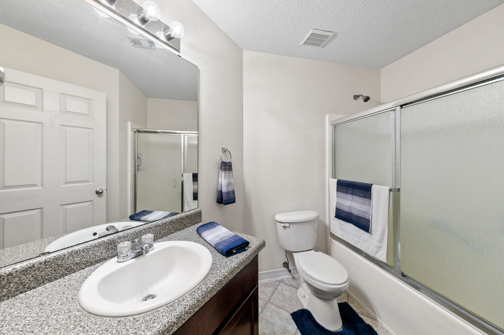 6735 Britt Street Navarre, FL 32566 - Photo 29 of 42 a bathroom with a granite countertop sink toilet a mirror and shower