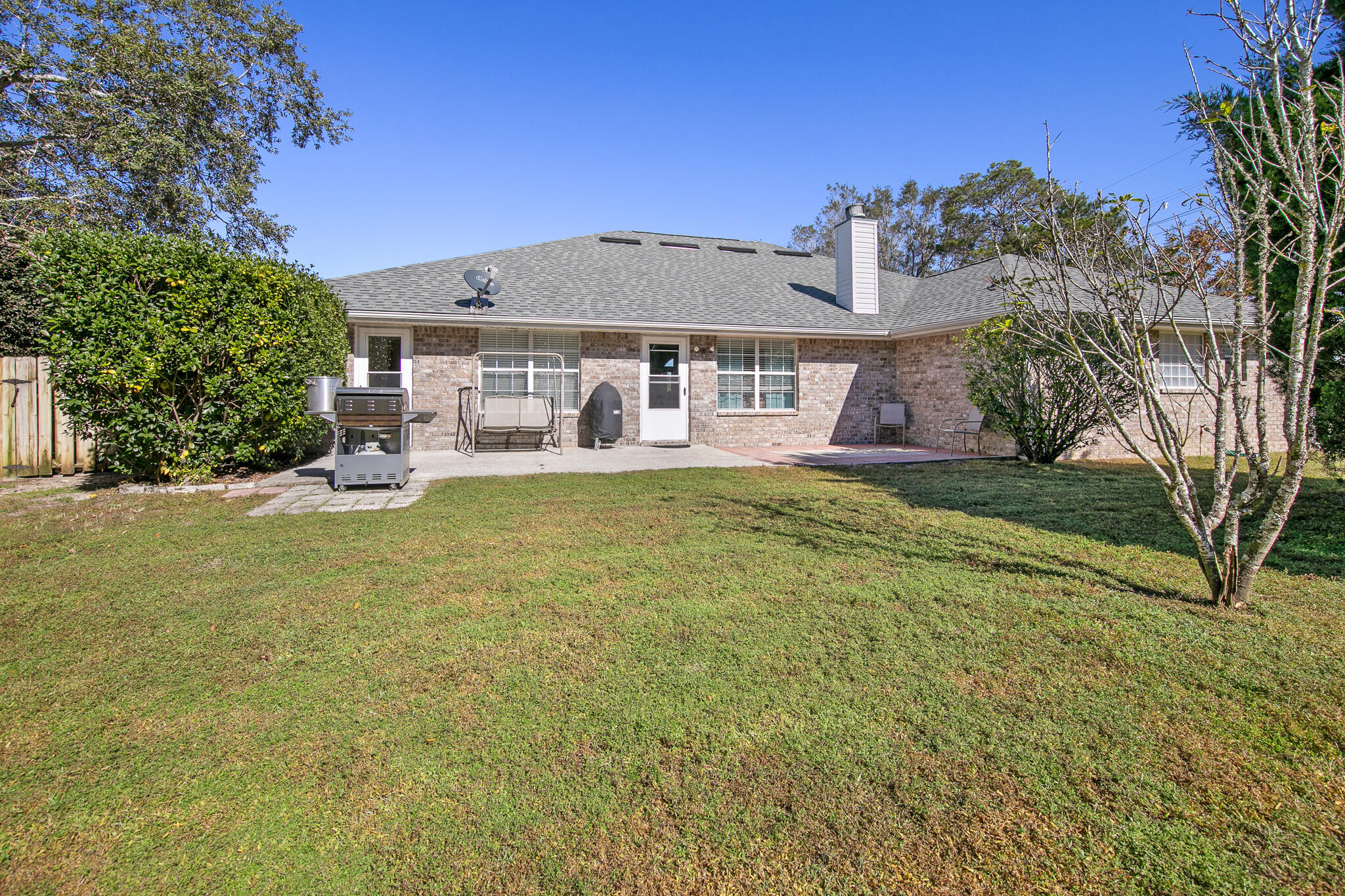 6735 Britt Street Navarre, FL 32566 - Photo 42 of 42 a view of a big house with a big yard and large trees