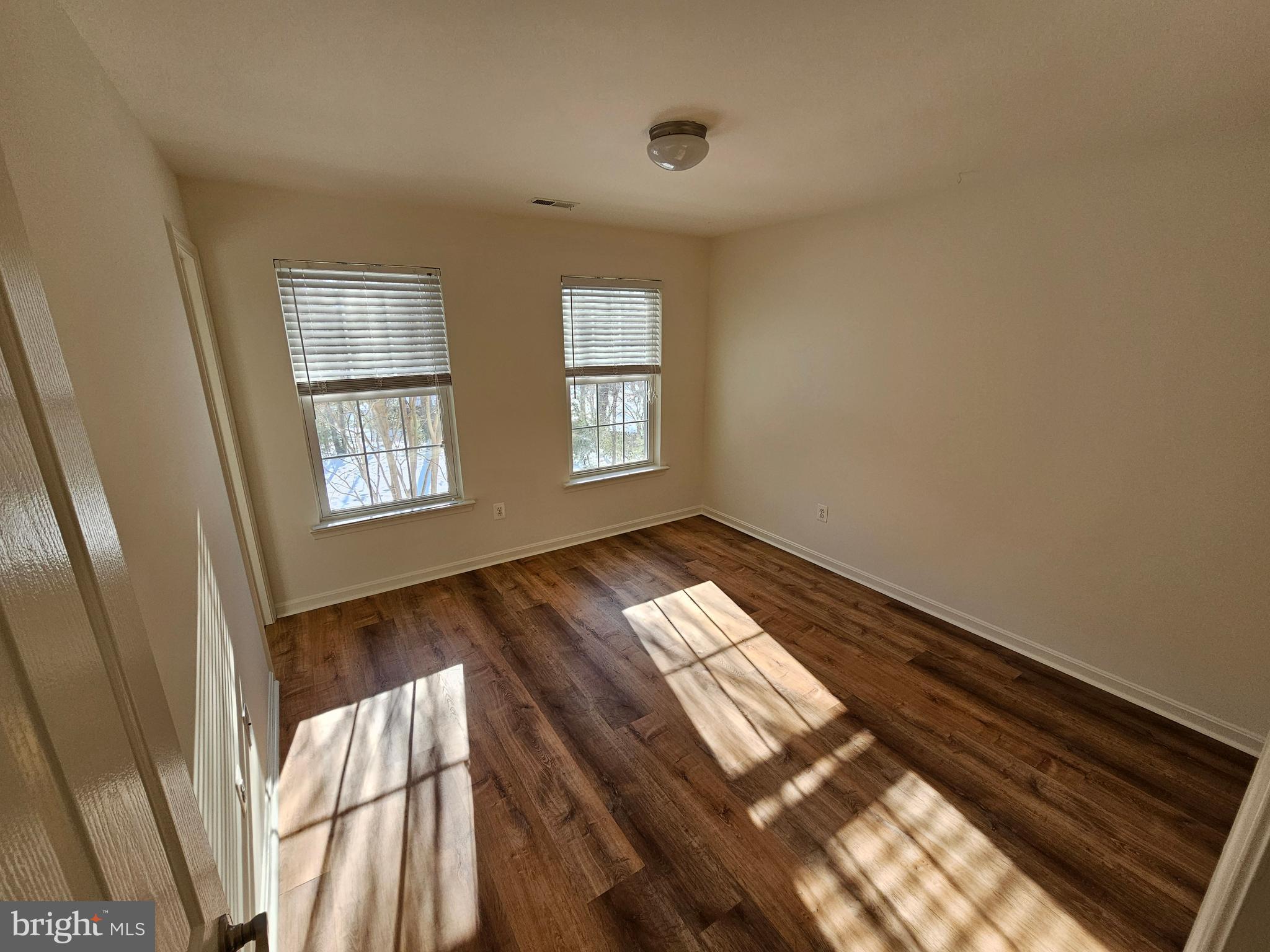 12560 Sagebrush Drive Lusby, MD 20657 - Photo 28 of 43 a view of an empty room and wooden floor and windows