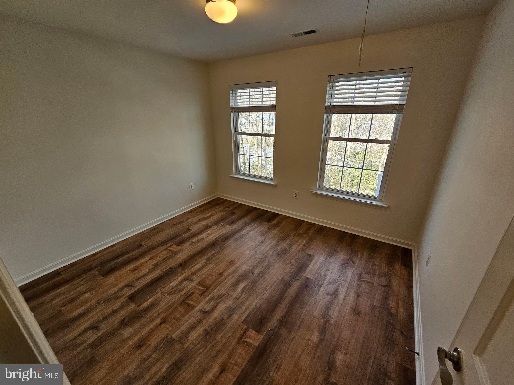 12560 Sagebrush Drive Lusby, MD 20657 - Photo 30 of 43 an empty room with wooden floor and windows