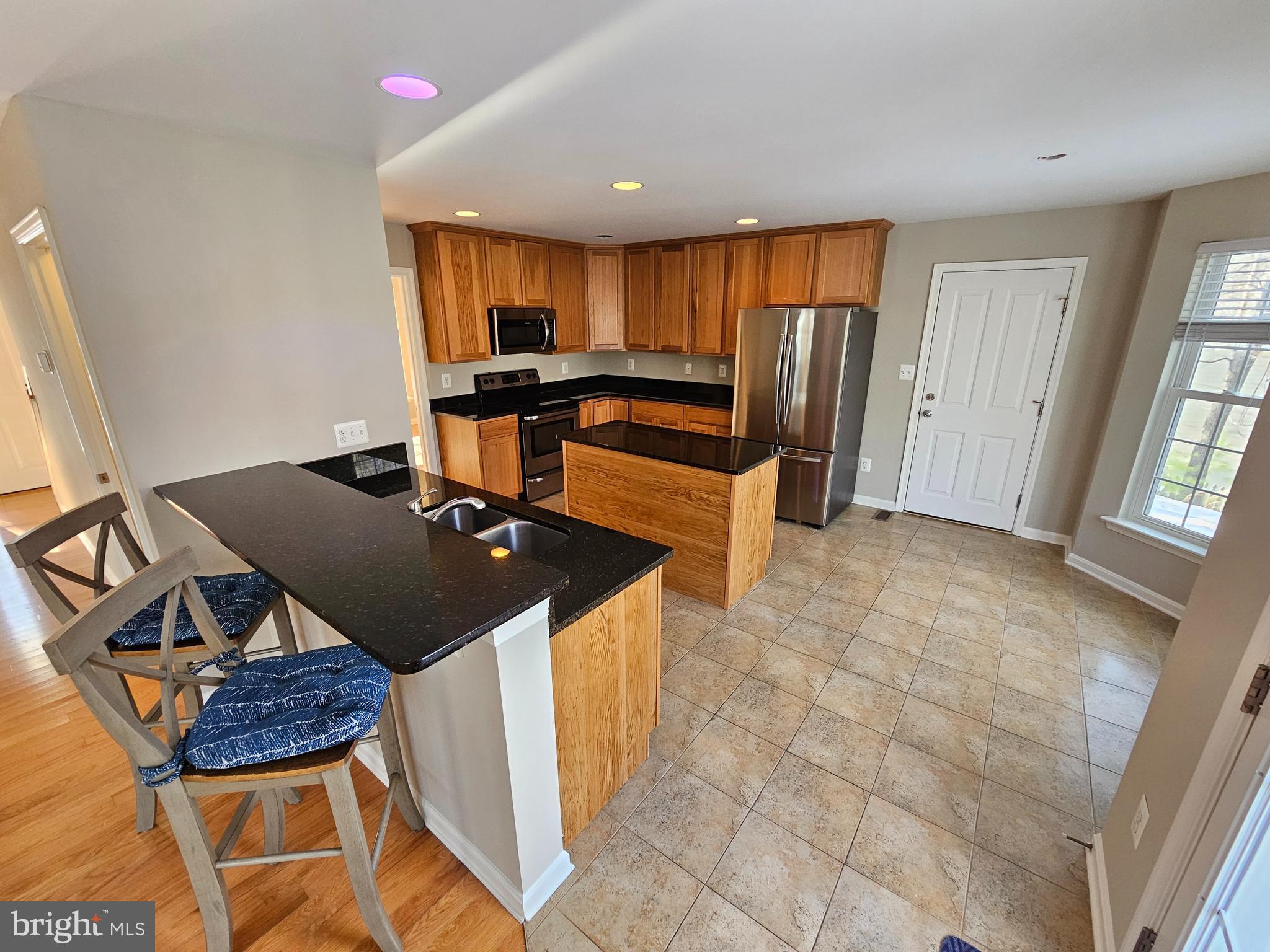12560 Sagebrush Drive Lusby, MD 20657 - Photo 6 of 43 a kitchen with granite countertop a stove a sink and a refrigerator