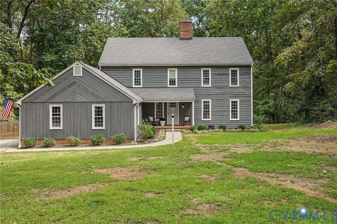 a front view of a house with a yard and trees